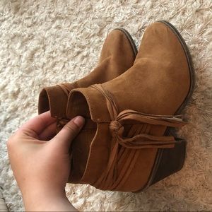 Heeled brown tasseled boots.